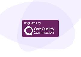 A young man sits wrapped in a warm blanket indoors, appearing pensive and comfortable.